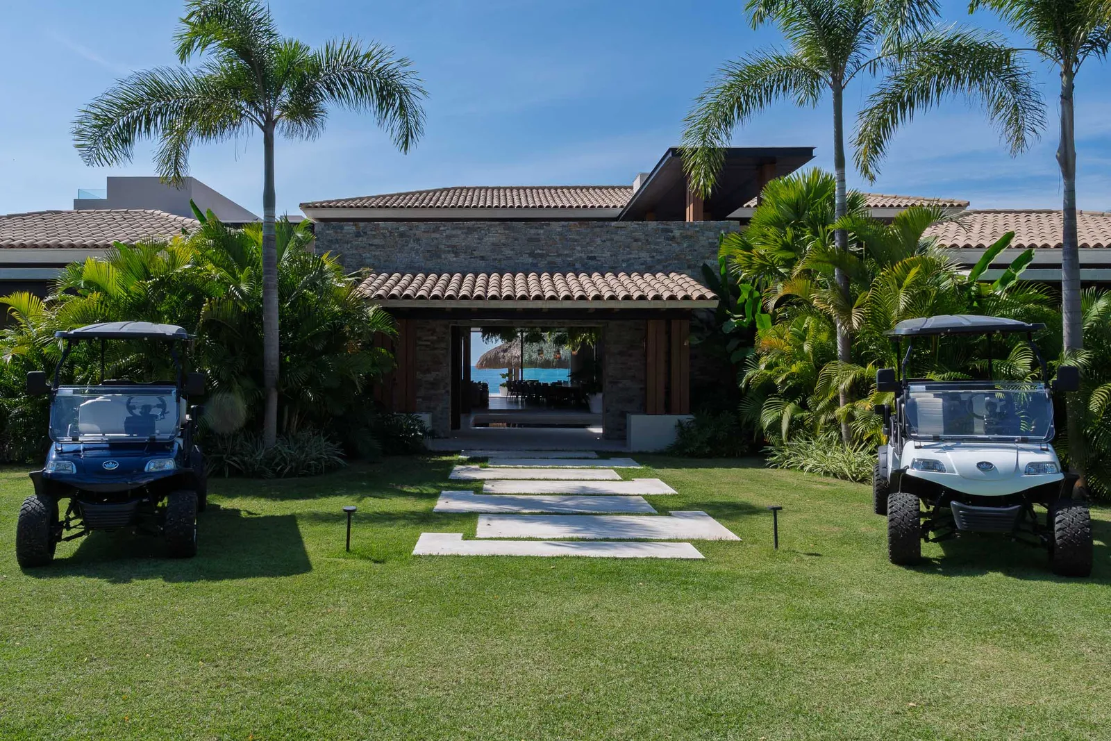 Golf carts parked either side of the stepping-stone path on the entry lawn