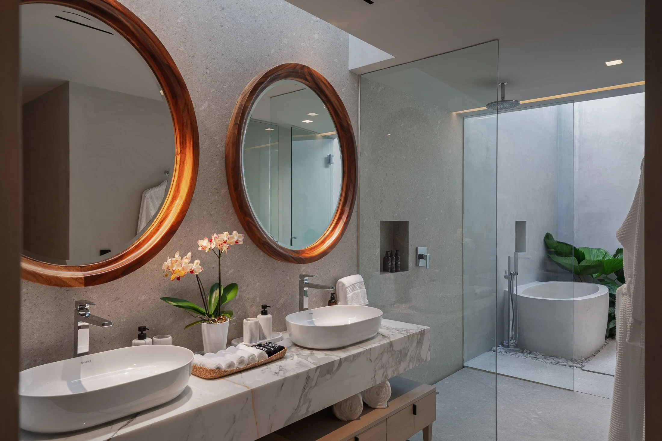 Earth’s bath — round mirrors over the double vanity, the tub past the glass