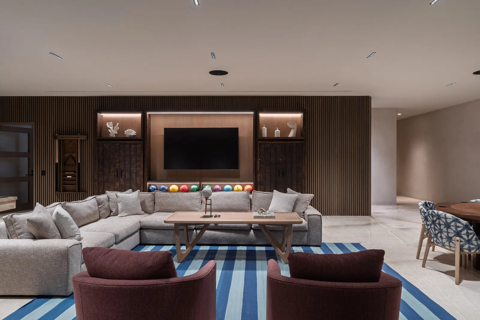 The lounge wall — a rack of bowling balls glowing beneath the screen