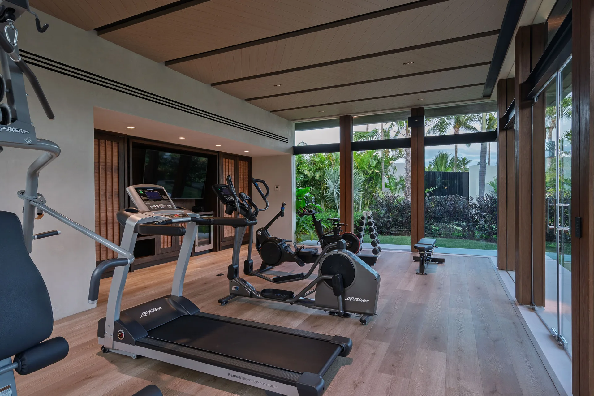 The fitness studio — machines facing the gardens through glass walls
