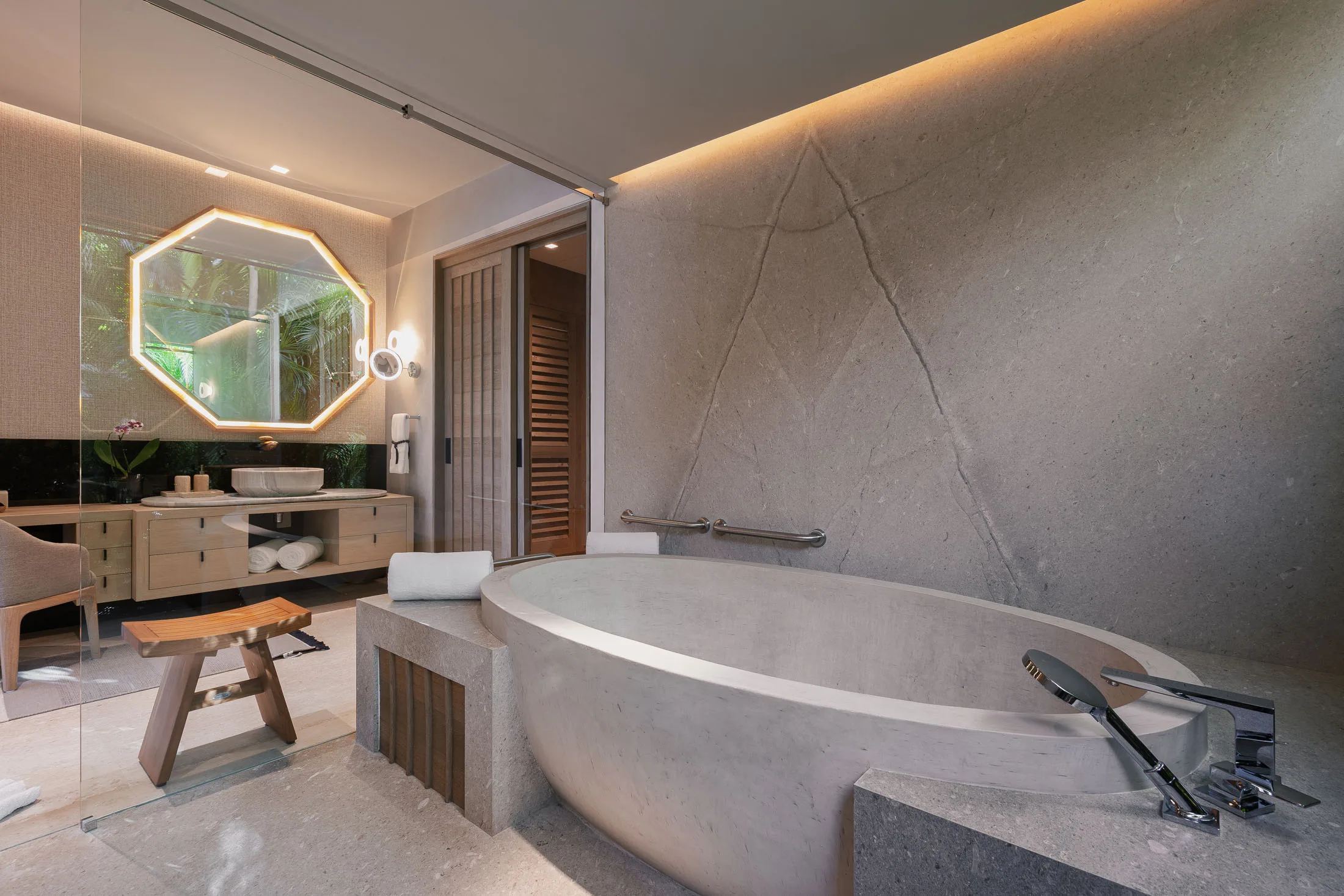 The Ocean Suite’s round soaking tub, carved from pale stone beneath a marble wall