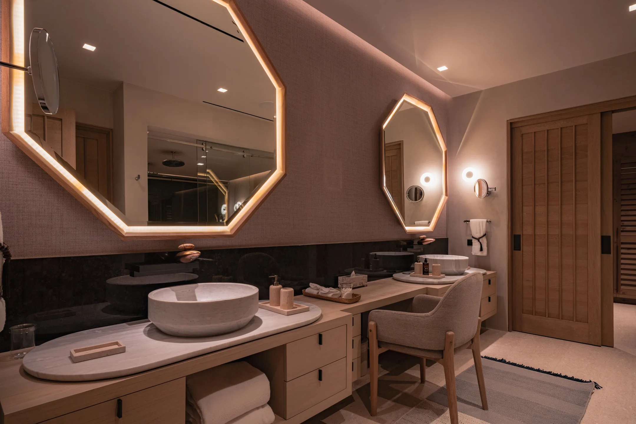 The vanity up close — the carved stone basin under the lit octagonal mirror