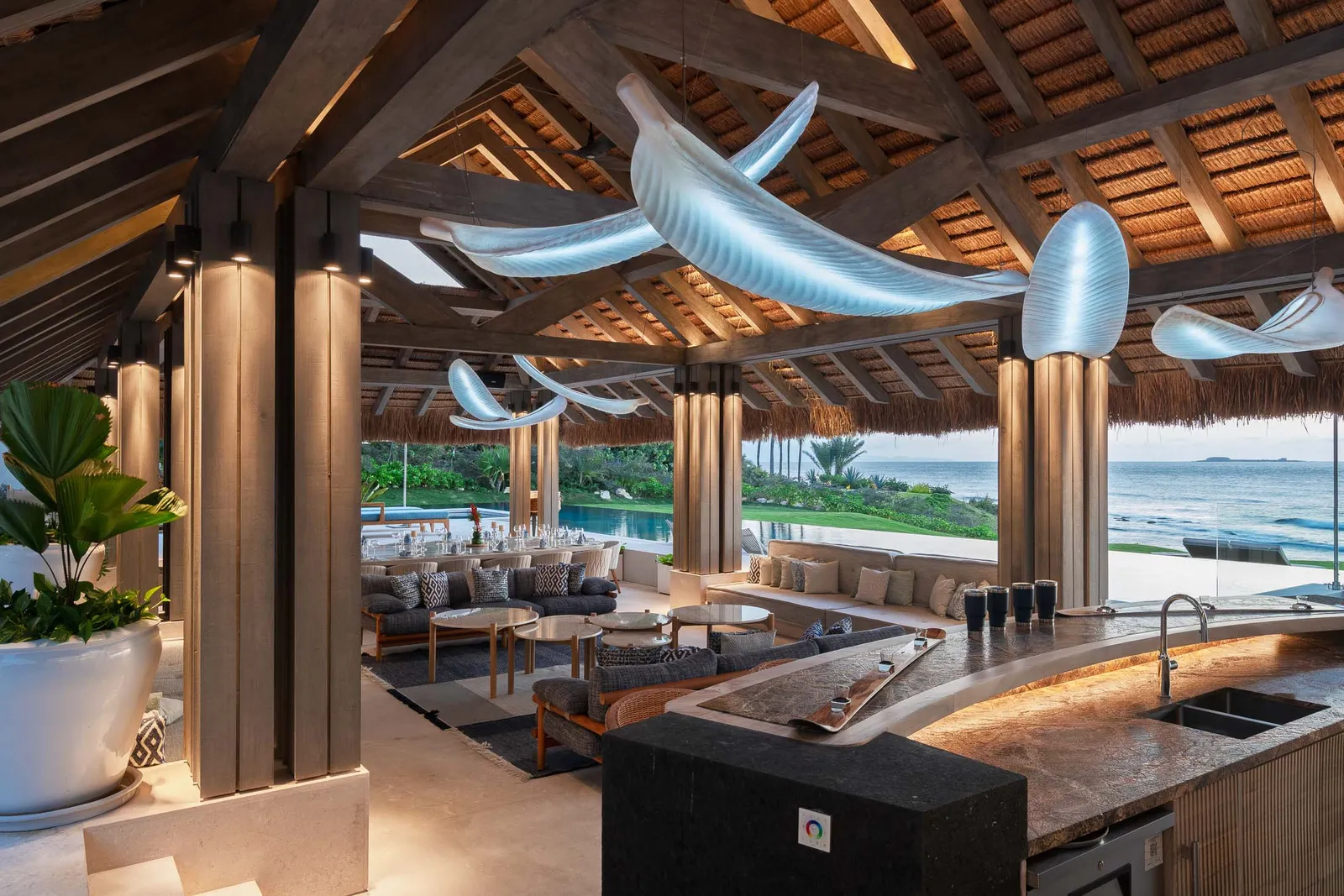 The palapa’s curved stone bar, the pool and ocean beyond the pillars