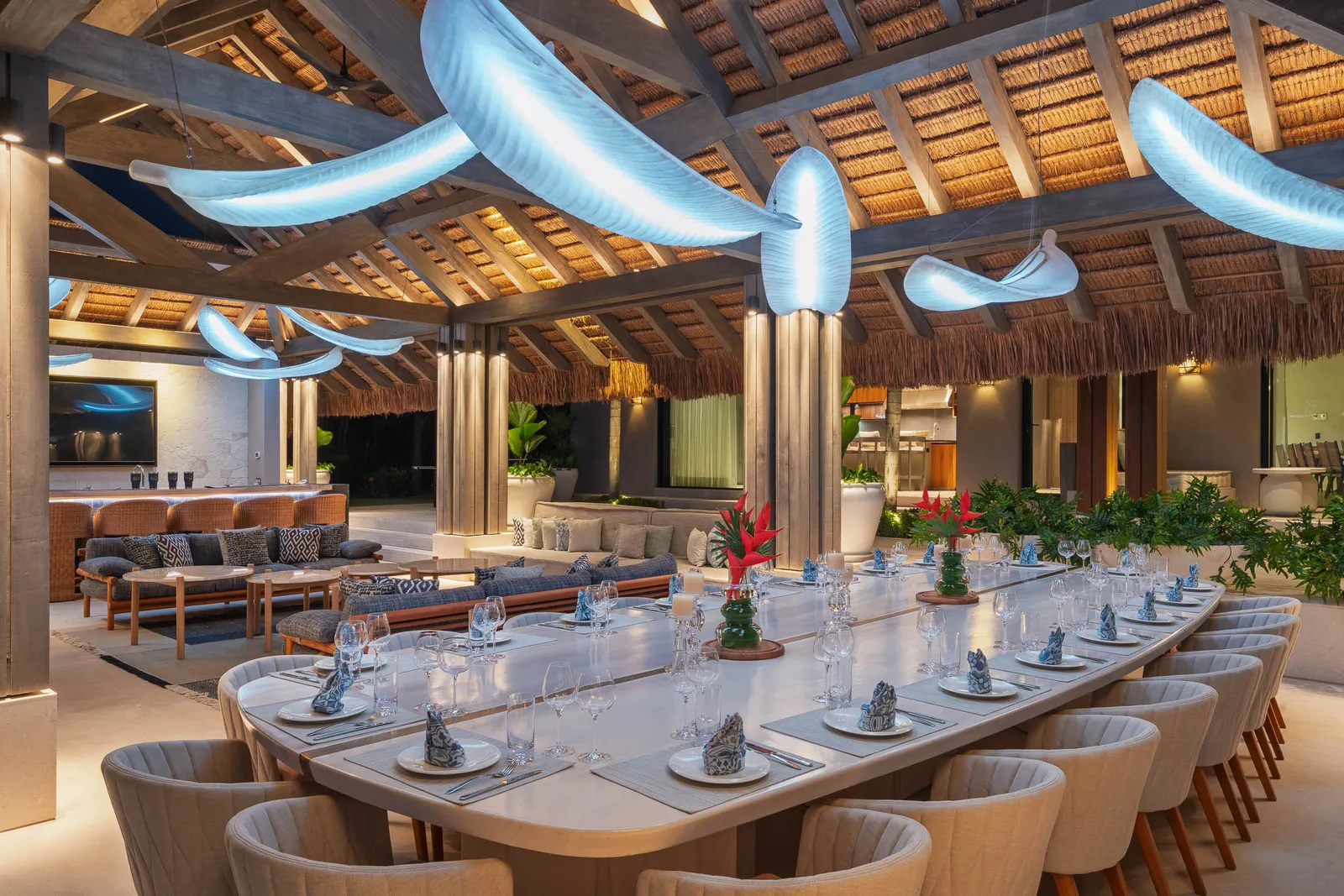 The long table set for dinner, the lounge and big screen behind