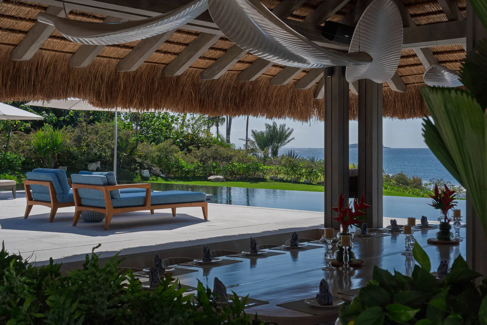 Loungers on the palapa’s pool deck under the edge of the thatch