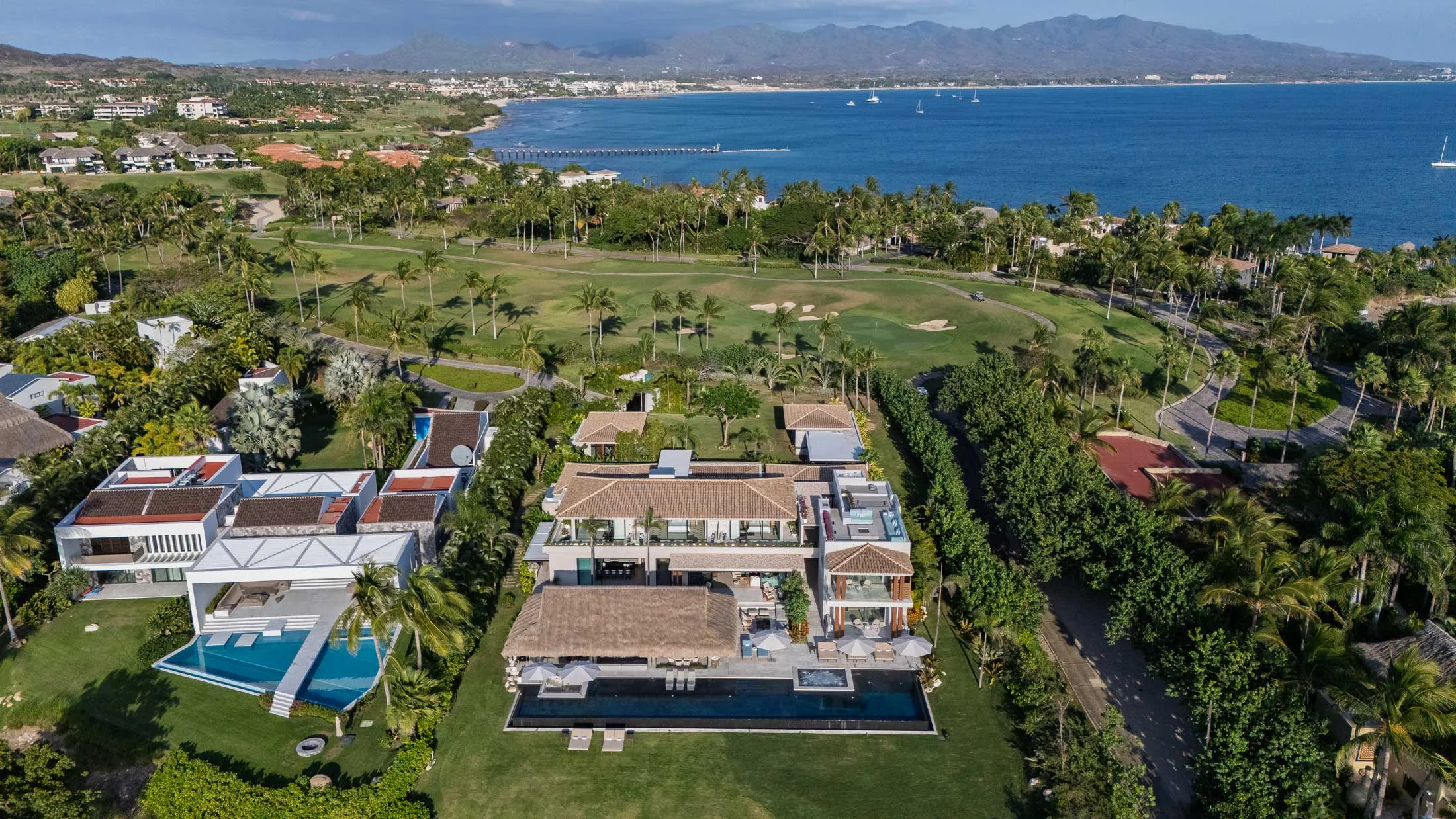 From above the house — fairways, Banderas Bay and the mountains of Punta Mita beyond the gate