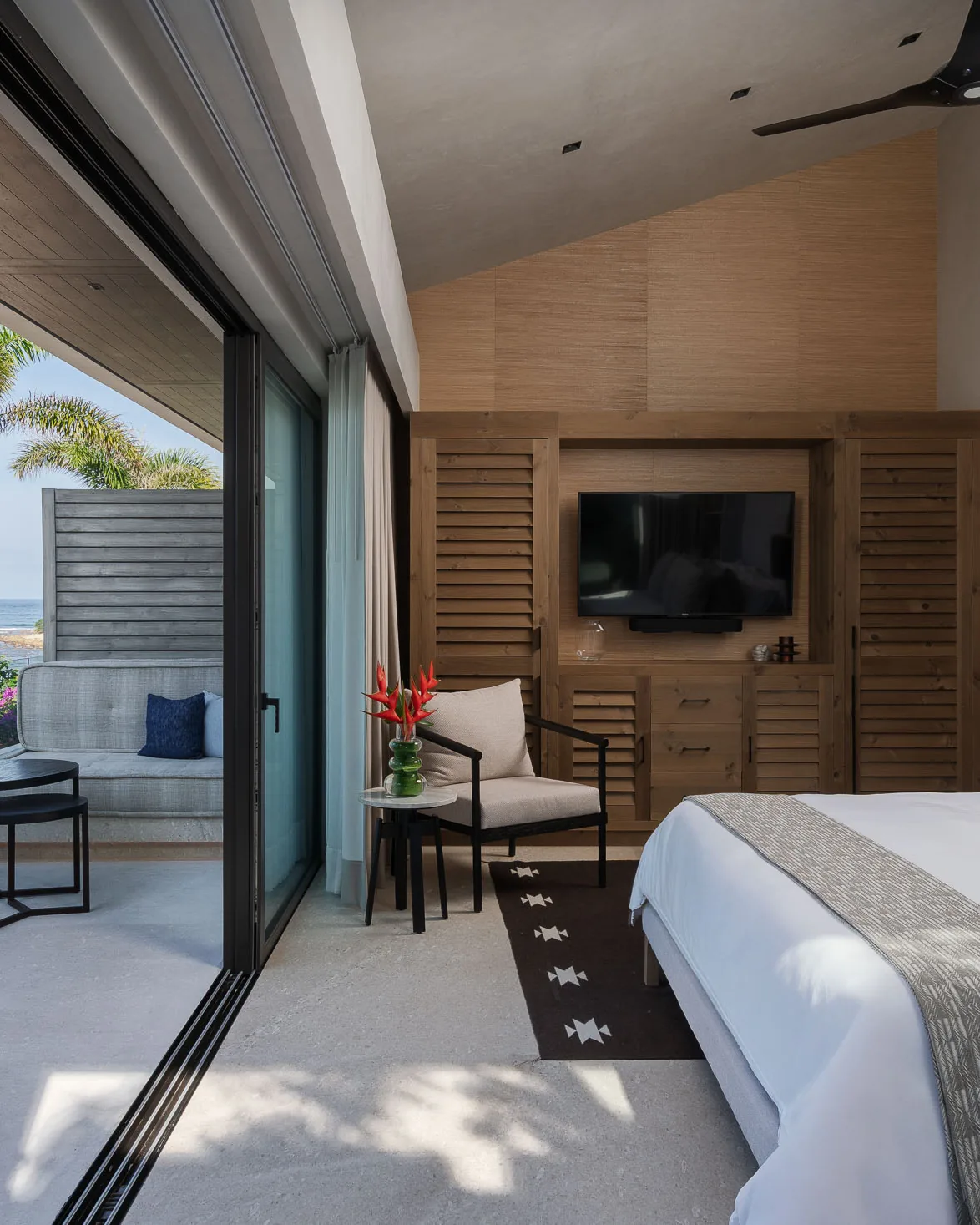 The Rivers Suite — king bed beside its private terrace, bougainvillea past the rail