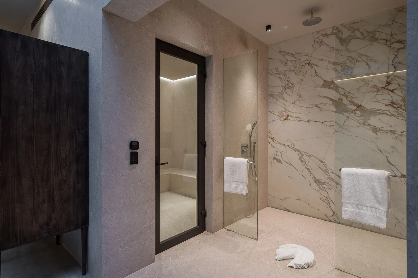 The marble steam shower, towels warm on the rail