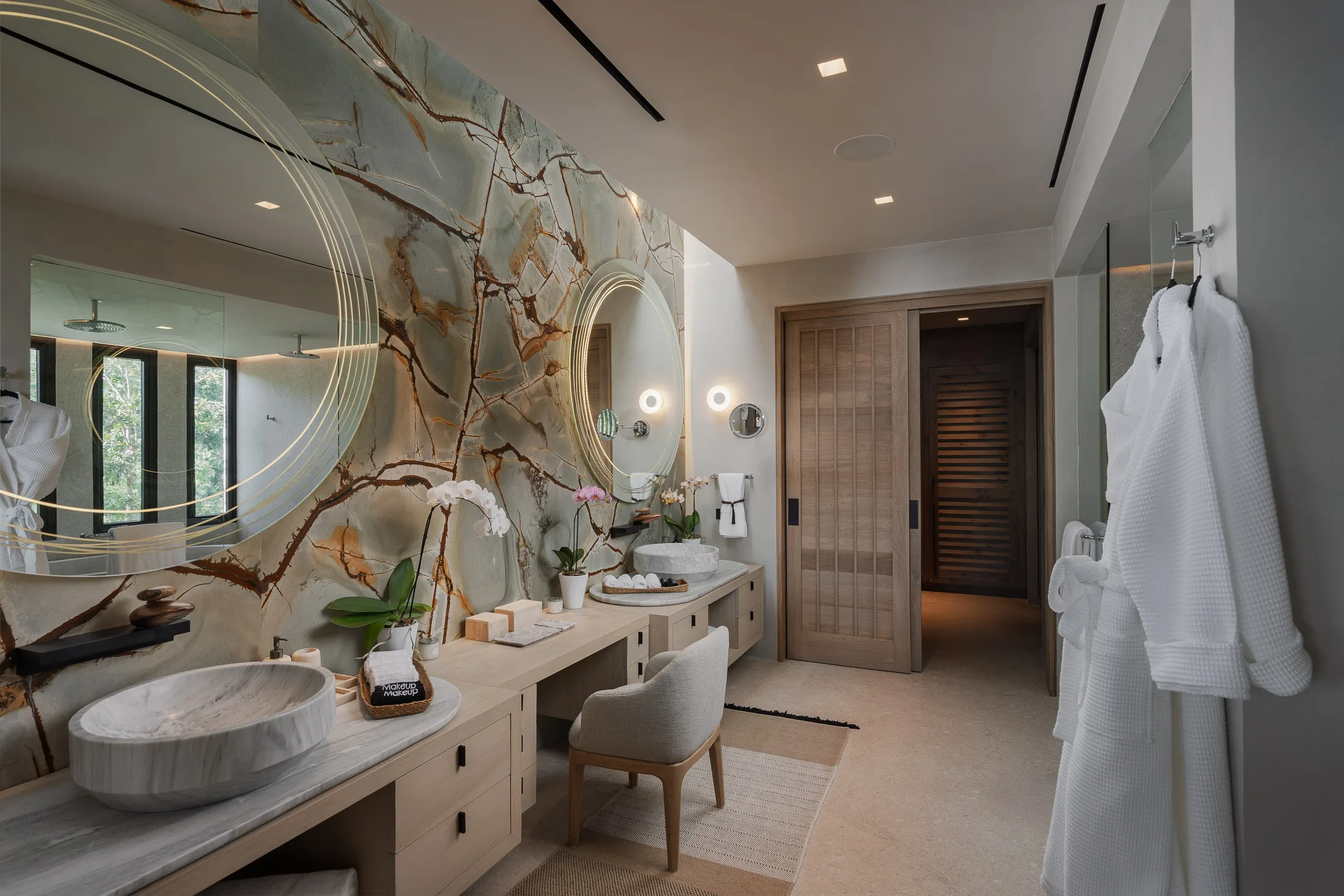 The Star Suite bath’s long stone counter, robes hung ready by the door