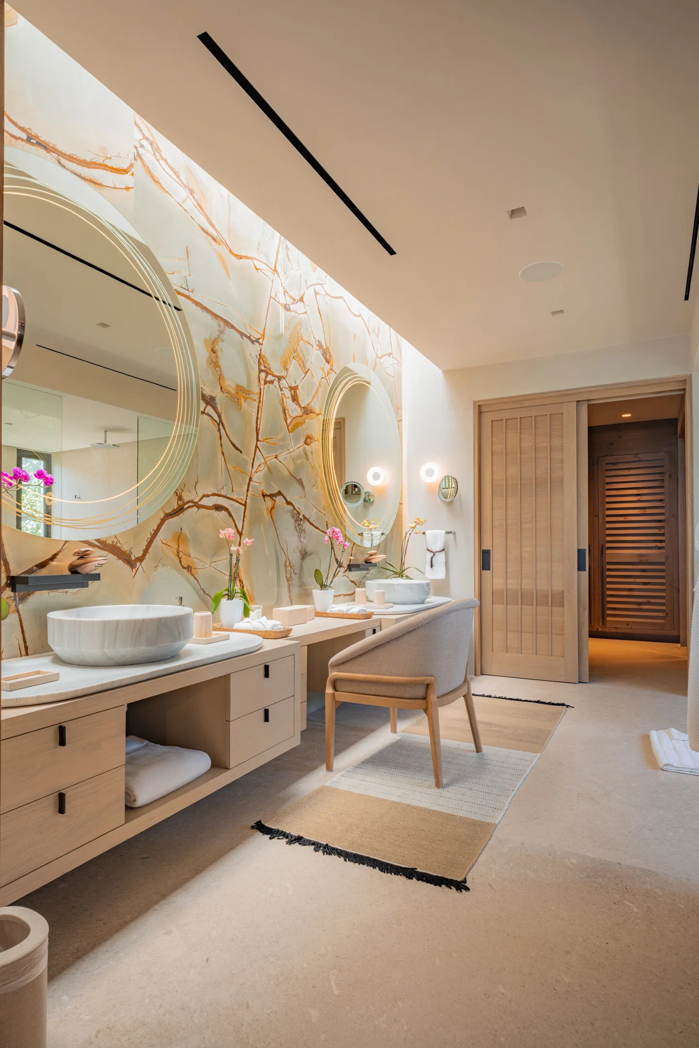 The Star Suite bath wide — the onyx wall, vanity chair and the sliding door to the closet beyond