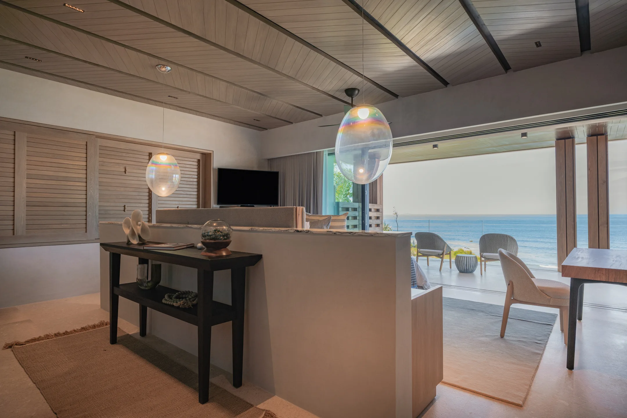 The Star Suite’s entry — the writing desk and bar with the ocean waiting past the glass