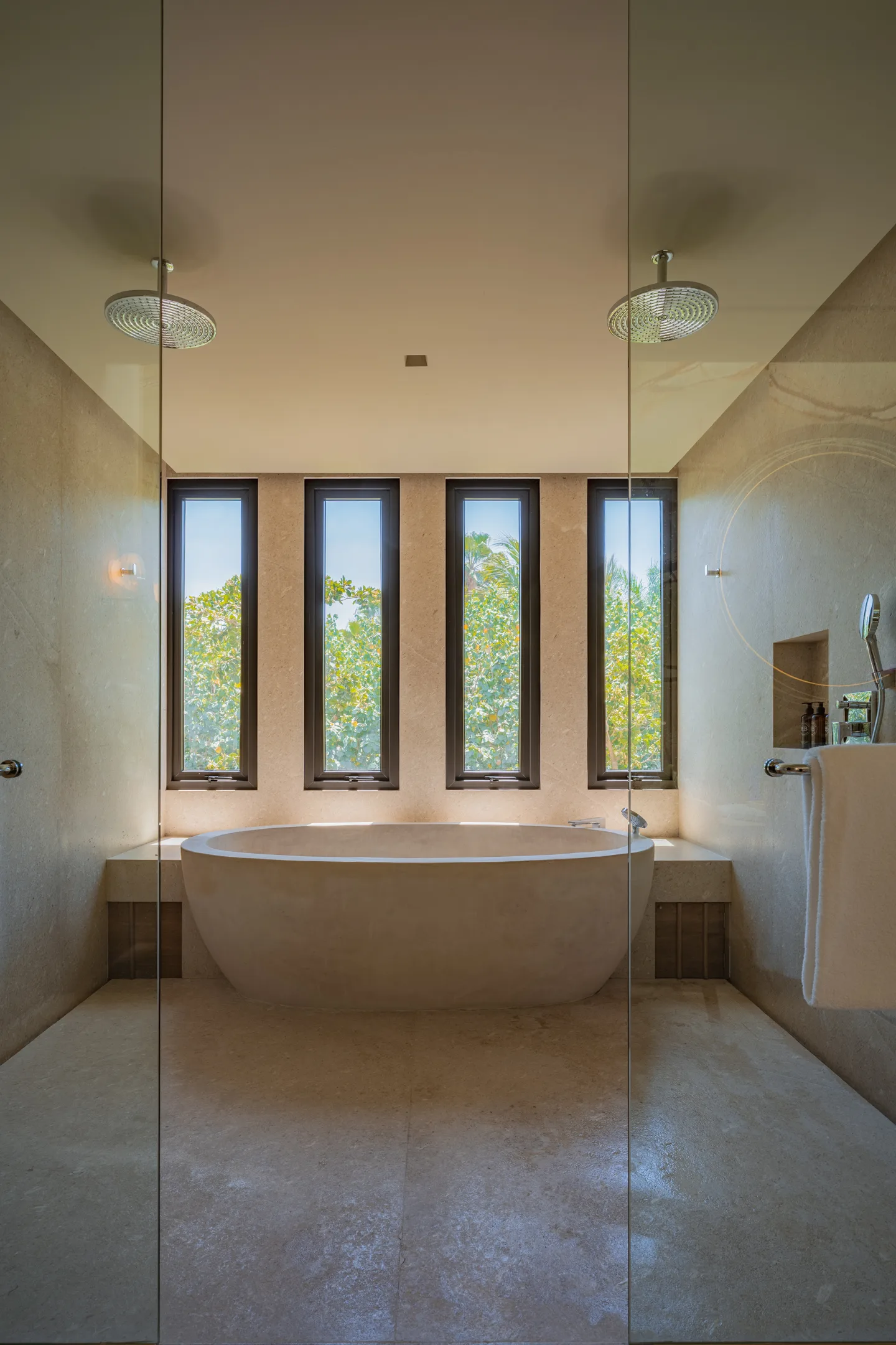 The round stone tub beneath four tall windows onto the jungle
